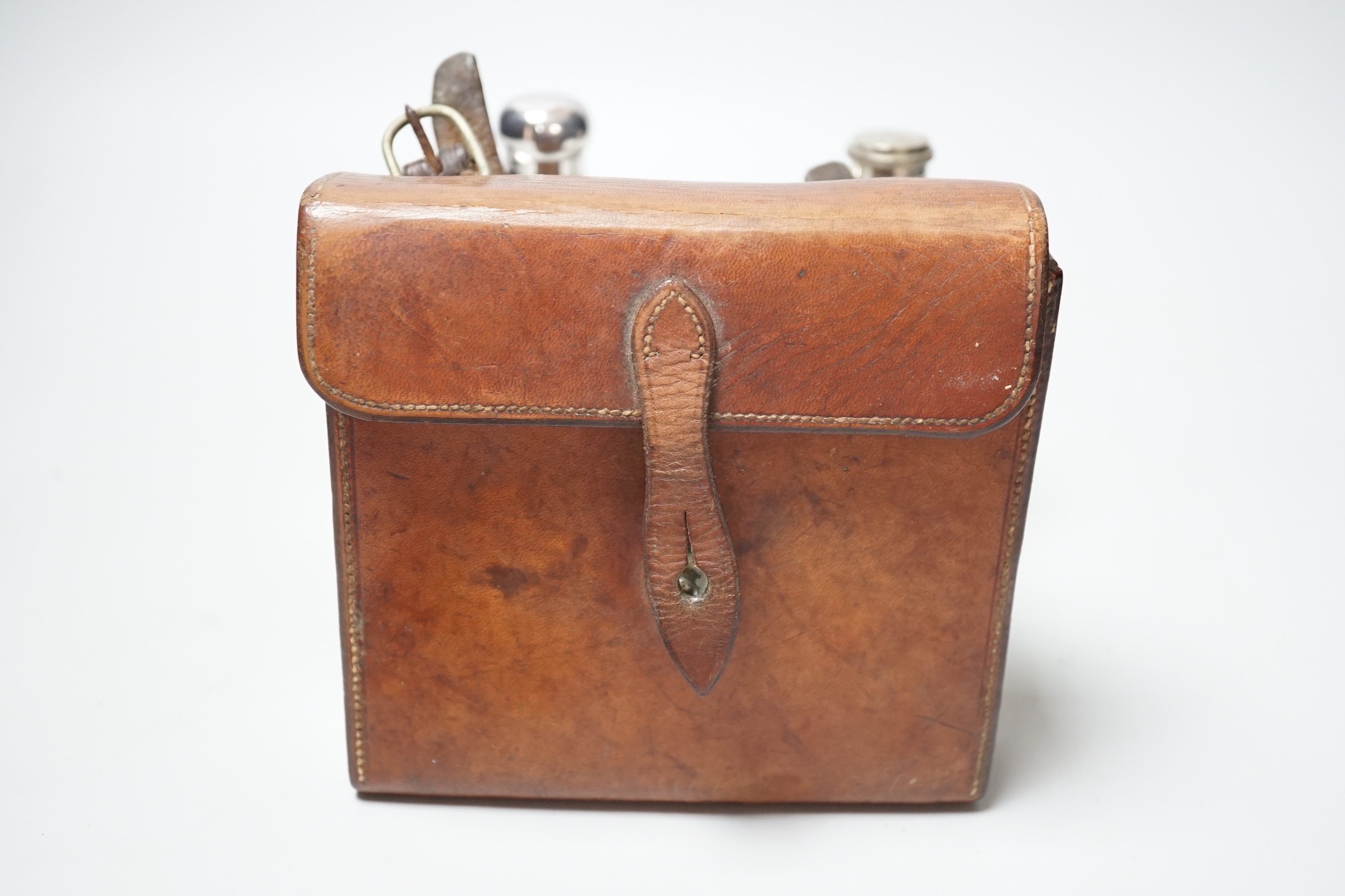 An Edwardian silver hip flask, Chester, 1905, 13.7cm, together with a white metal mounted glass scent flask, housed in an associated? leather carrying case.